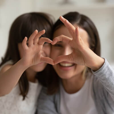 Mom and daughter making heart with hands - Jenison Office